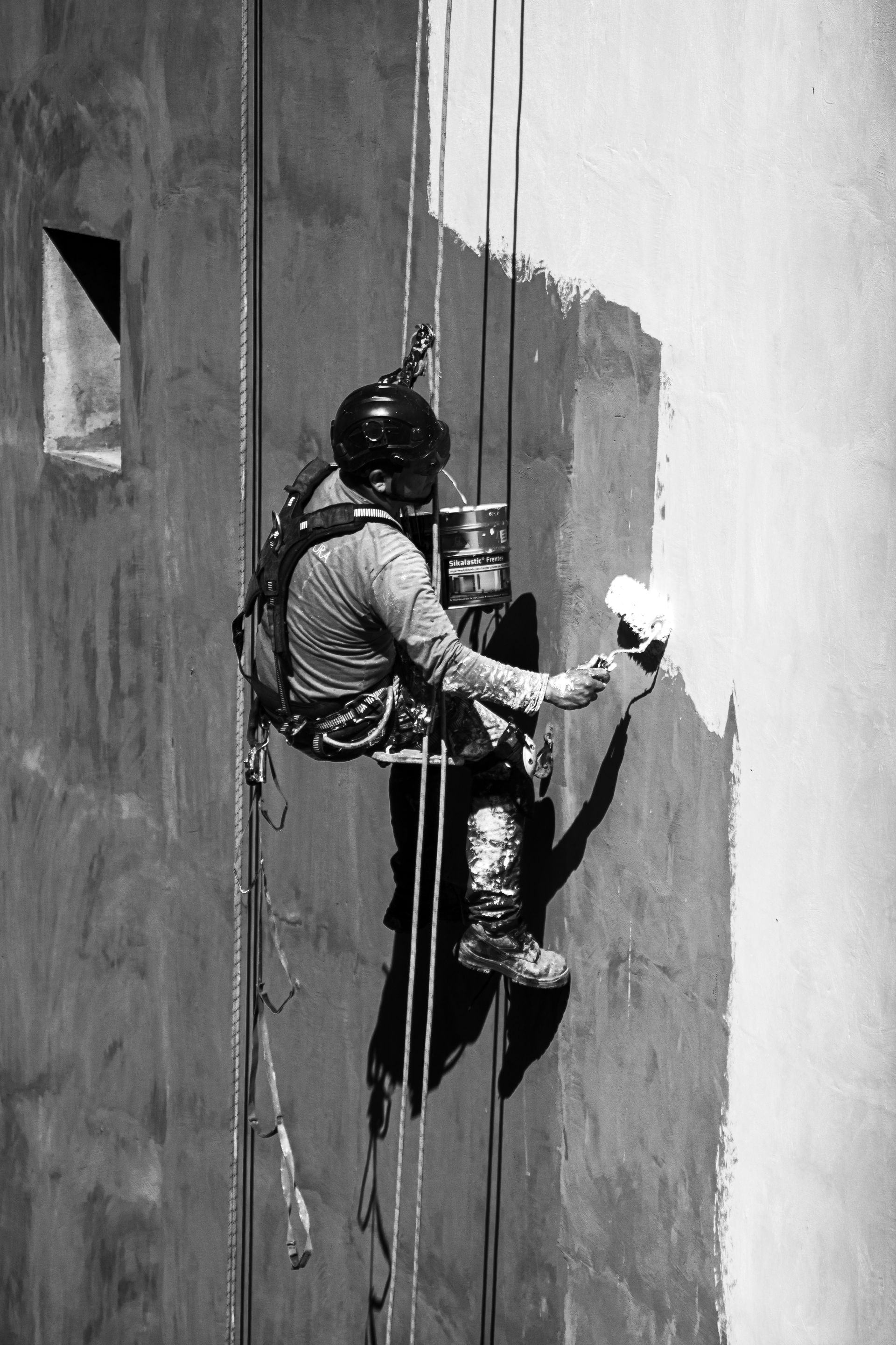 Alpinista industrial da Alfa San trabalhando em fachada de edifício